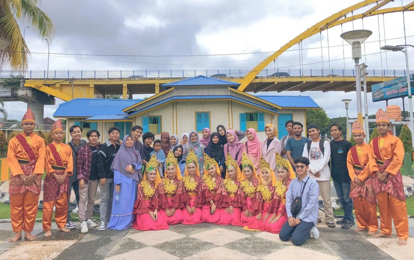 Foto bersama penari Melayu berlatar rumah Tuan Kadi dan Jembatan Siak