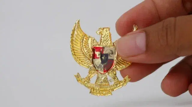 Yogyakarta, Indonesia - 23 Mei 2021 : Bergandengan Tangan dengan Garuda Pancasila, Simbol Nastional Indonesia. Hari kemerdekaan Indonesia 17 Agustus. Terisolasi di atas putih