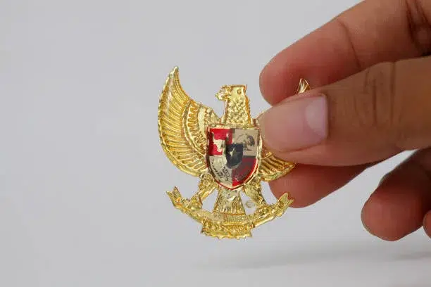 Yogyakarta, Indonesia - 23 Mei 2021 : Bergandengan Tangan dengan Garuda Pancasila, Simbol Nastional Indonesia. Hari kemerdekaan Indonesia 17 Agustus. Terisolasi di atas putih