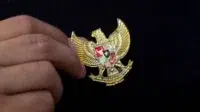 Yogyakarta, Indonesia - 23 Mei 2021 : Bergandengan tangan dengan Garuda Pancasila pada pakaian, Simbol Nastional Indonesia. Hari kemerdekaan Indonesia 17 Agustus.