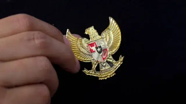 Yogyakarta, Indonesia - 23 Mei 2021 : Bergandengan tangan dengan Garuda Pancasila pada pakaian, Simbol Nastional Indonesia. Hari kemerdekaan Indonesia 17 Agustus.