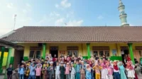 Gambar 1. Foto bersama mahasiswa KKN-Berdampak 119 UMM, pengajar TPQ, dan seluruh santri di halaman TPQ Desa Gampingan